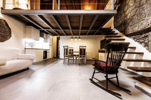 a living room with a staircase and a chair at La Soffitta della nonna in Ronciglione