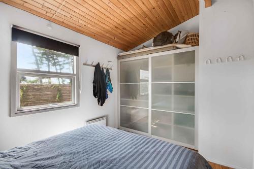 a bedroom with a bed and a window at Holiday Home On The Beach With Panoramic View in Store Fuglede