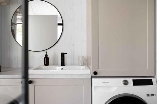 a white bathroom with a sink and a mirror at Newly Built Luxury House On Bornholm in Hasle