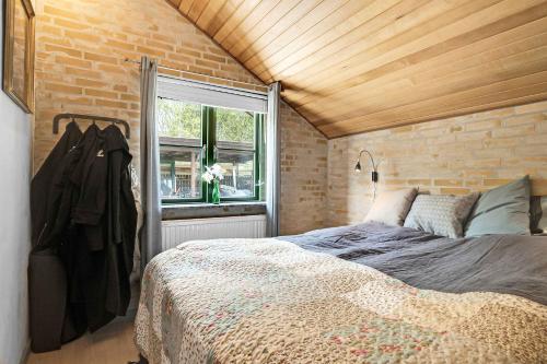 a bedroom with a bed and a brick wall at Lovely Summer Villa In Natural Surroundings in Rødby