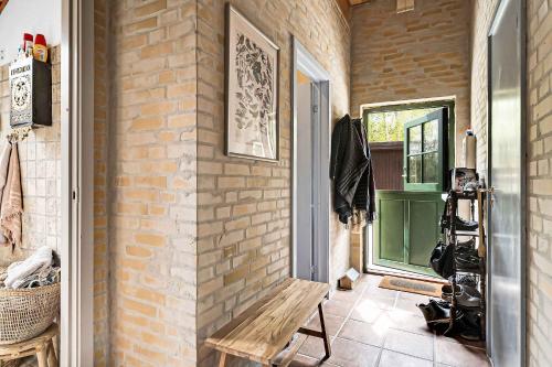 a room with a wooden bench next to a brick wall at Lovely Summer Villa In Natural Surroundings in Rødby