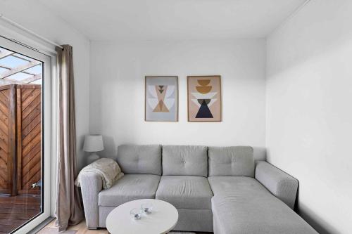 a living room with a couch and a table at Newly Renovated Holiday Apartment On Bornholm in Neksø