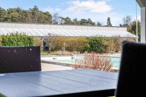a table and chairs in front of a swimming pool at Newly Renovated Holiday Apartment On Bornholm in Neksø
