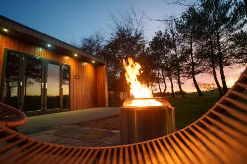 a fire pit in a hammock in front of a building at Hygge at Vallum in Newcastle upon Tyne