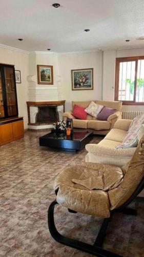 a living room with two couches and a fireplace at Villa Iluminada con chimenea, barbacoa y piscina cerca Playa in Elche