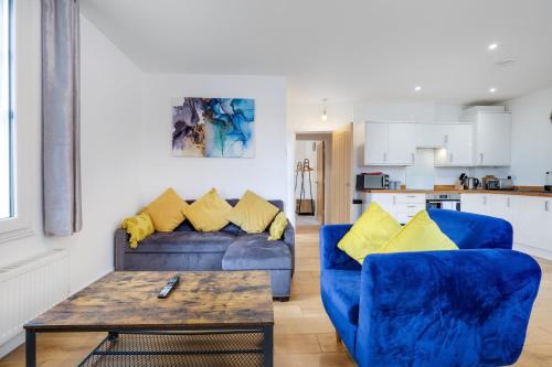a living room with two blue couches and a table at Eastons 2 Bedroom Apartment with Sofa Bed in High Wycombe