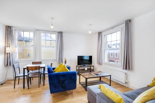 a living room with a blue couch and a table at Eastons 2 Bedroom Apartment with Sofa Bed in High Wycombe