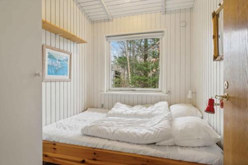 un letto in una stanza con una finestra di Cozy Cottage Near Limfjorden a Roslev