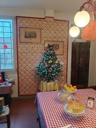 a christmas tree in a room with a table at La Maison Rouge in Crespellano