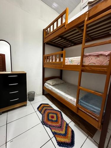 two bunk beds in a room with a rug at Casa da praia Atins Maranhão in Atins