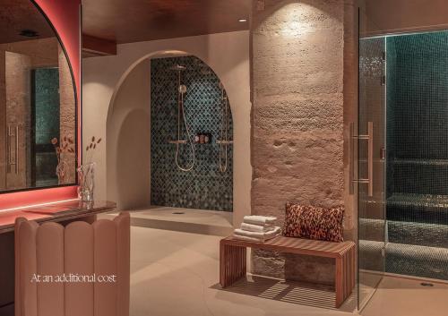 a bathroom with a shower and a bench in front of a shower at Boudoir des Muses in Paris