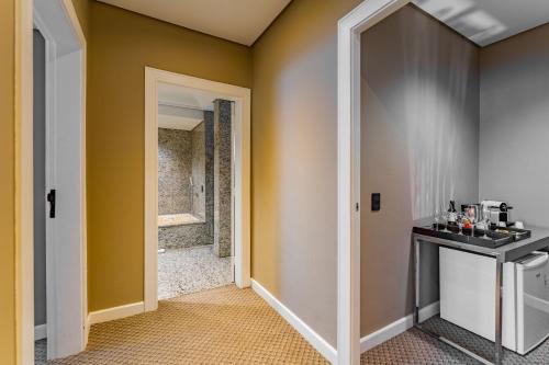 a hallway with a door leading to a bathroom at Grand Mercure Curitiba Rayon in Curitiba