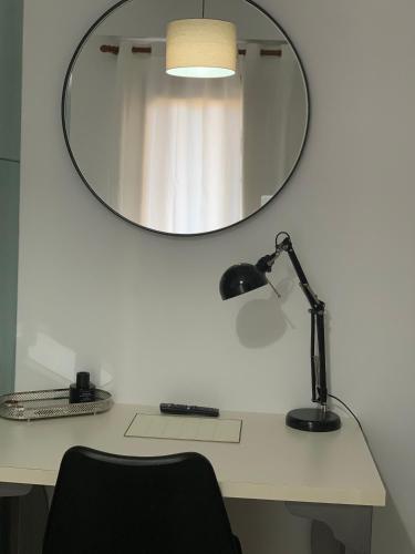 a desk with a lamp and a mirror on a wall at Aelin Living in Agrinion