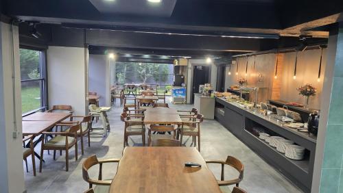 een restaurant met houten tafels en stoelen en een keuken bij YOUR HOUSE Apart Otel in Karaköprü Köyü