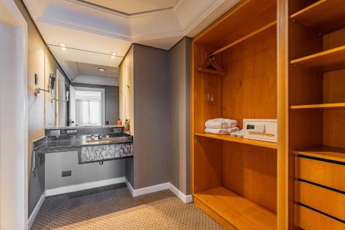 a bathroom with a counter and a sink at Grand Mercure Curitiba Rayon in Curitiba