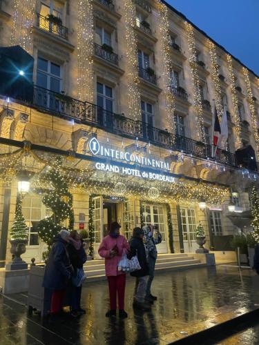 a group of people standing in front of a building with christmas lights at La Villa Bocage in Bordeaux
