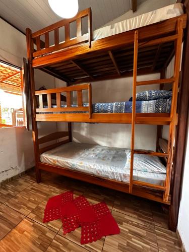 two bunk beds in a room with red bows on the floor at Casa da praia Atins Maranhão in Atins
