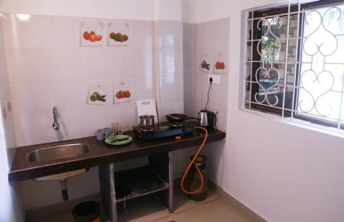 a small kitchen with a sink and a window at Kumbaya Beachside Hostel & Apartments at Arambol Beach in Arambol