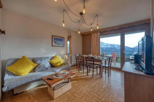 a living room with a couch and a table at L'AlpinEscapade - Parking - Ski in Chamrousse