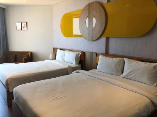 a hotel room with two beds and a mirror at Apec Mandala Romantic Mui Ne in Ấp Thiẹn Ái