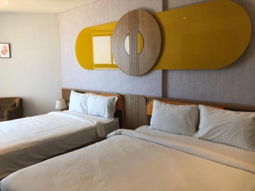 a hotel room with two beds and a mirror at Apec Mandala Romantic Mui Ne in Ấp Thiẹn Ái