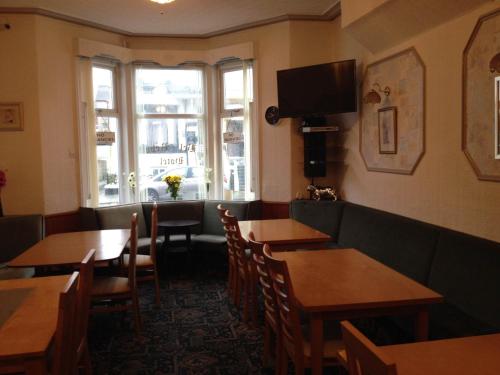 a restaurant with tables and chairs and a window at Bel Reve Hotel in Blackpool