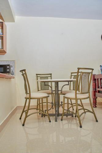 a dining room table with four chairs around it at SHIMBA SPRINGS MBUYU. ( Malindi) in Malindi