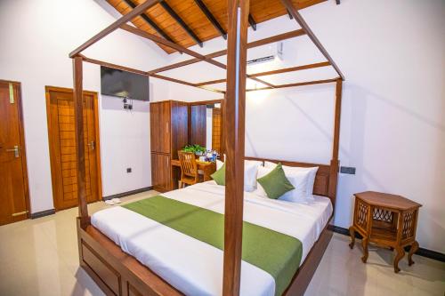 a bedroom with a canopy bed and a table at Villa Freedom in Hikkaduwa