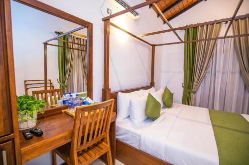 a bedroom with a bed and a desk and a table at Villa Freedom in Hikkaduwa