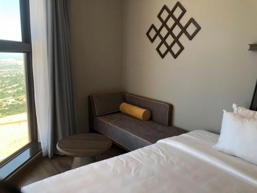 a bedroom with a bed and a chair and a window at Apec Mandala Romantic Mui Ne in Ấp Thiẹn Ái