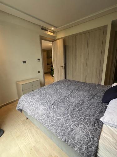 a bedroom with a large bed with a gray blanket at 5 minutes walk to the sea appartement in Casablanca