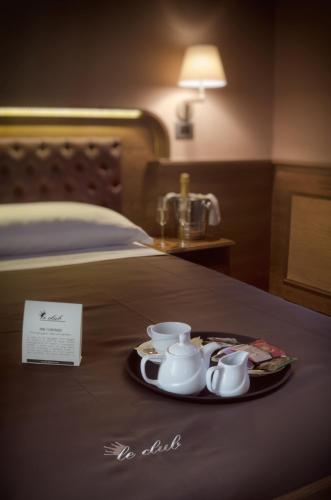 a tray of tea cups and saucers on a bed at Le Club Boutique Hotel in Lecce