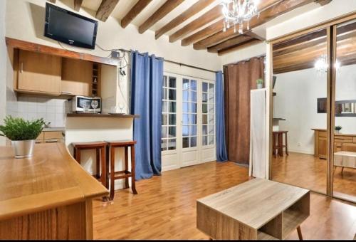 Il comprend une cuisine avec une table et des rideaux bleus. dans l'établissement Appartement Design Champ de Mars, 2 piéces Quartier Tour Eiffel, à Paris