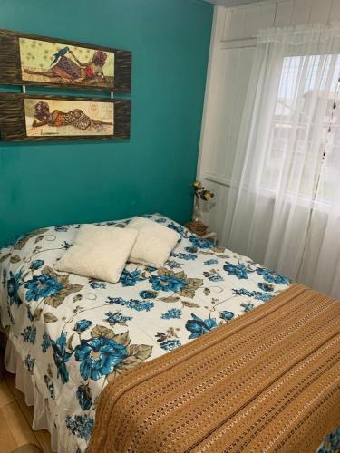 a bedroom with a bed with a blue wall at Casa da lagoa Doce!! in Imbituba