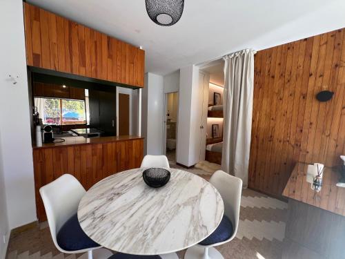 une cuisine et une salle à manger avec une table et des chaises dans l'établissement Studio grande terrasse Pra loup 1600, à Uvernet