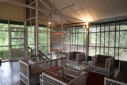 een lege kamer met stoelen en ramen in een gebouw bij Chowkidinghee Heritage Tea Bungalow in Dibrugarh