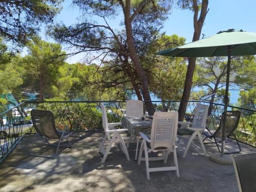 a patio with a table and chairs and an umbrella at House Vlasta in Primošten