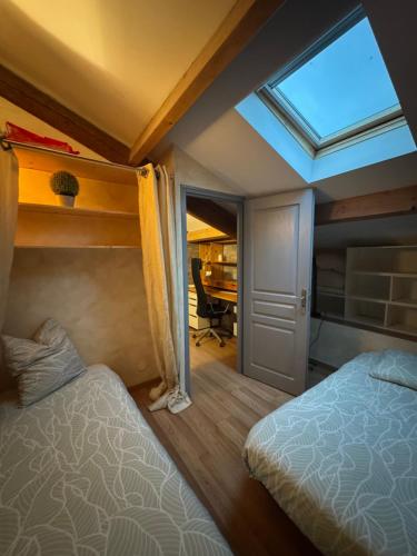 - une chambre avec 2 lits et une lucarne dans l'établissement la maison des lauriers rouges, à Peyriac-de-Mer