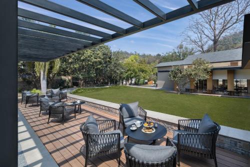 un patio con sedie, tavoli e un prato di ZANA Luxury Suites and Cottages, Dhikuli, Jim Corbett a Ramnagar