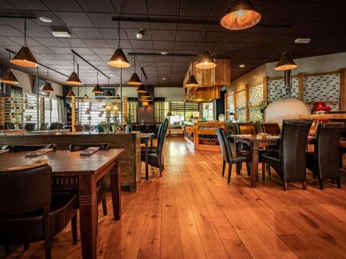 a dining room with wooden tables and chairs in a restaurant at Charming Hideaway Near Woods in Hellendoorn