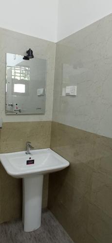 a bathroom with a white sink and a mirror at Sandakini Home Rest in Ahangama