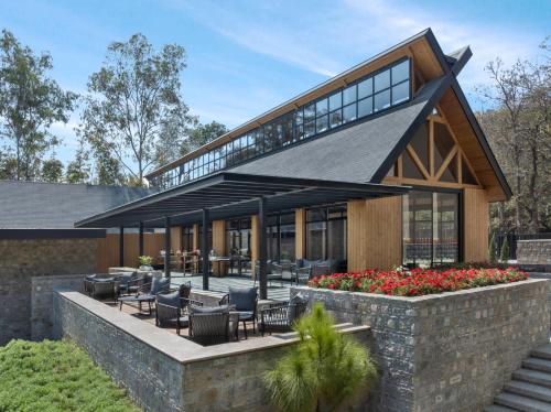 una vista esterna di una casa con sedie e fiori di ZANA Luxury Suites and Cottages, Dhikuli, Jim Corbett a Ramnagar
