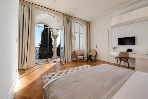 a bedroom with a large bed and a large window at Villa Ariston in Opatija