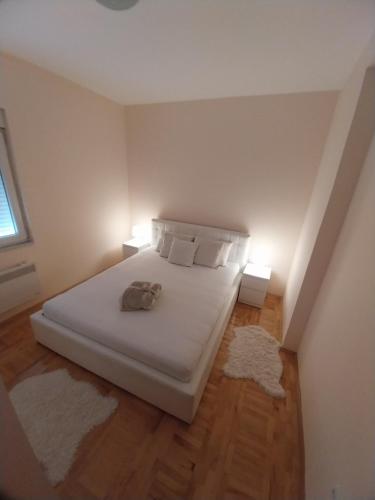 a bedroom with a white bed with two lamps at Sorin Apartments Gevgelija in Gevgelija