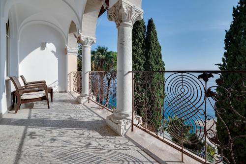 a balcony of a house with a fence and a chair at Villa Ariston in Opatija