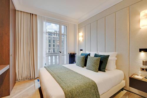 une chambre avec un grand lit avec une grande fenêtre dans l'établissement TheLander - Serviced Apartments in Saint Germain des Prés, à Paris