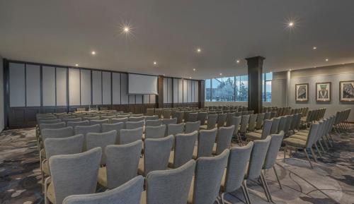 a large room with rows of chairs and a screen at Clayton Hotel, Leeds in Leeds