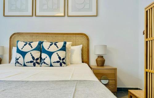 a bedroom with a bed with blue and white pillows at Canaryislandshost l Girasol in Punta de Mujeres