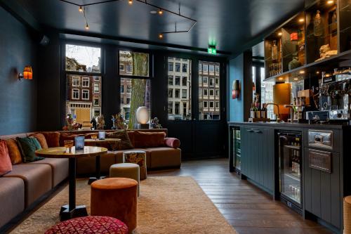 a living room with a couch and a table at Hotel Mai Amsterdam in Amsterdam