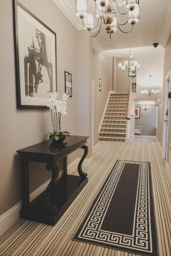 a hallway with a table with a vase on it at Kensington House by Warren Collection in Newcastle upon Tyne